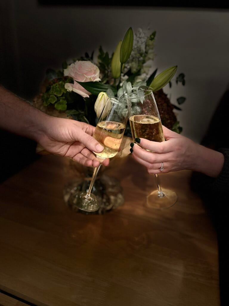 Celebrant Services | Two hands holding champagne glasses.
